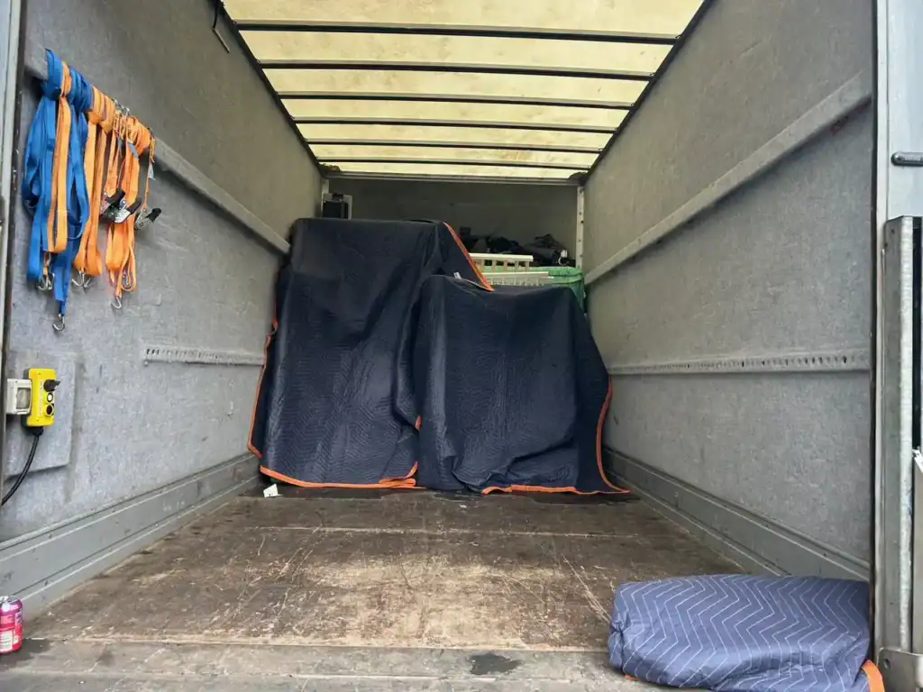Interior of SDS Man and Van removal truck with padded furniture and secure straps showing careful loading service in Plymouth Devon
